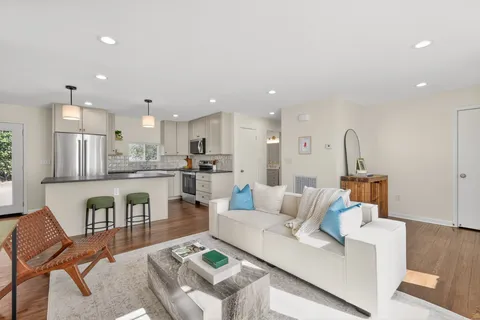 a kitchen with refrigerator a sink and chairs