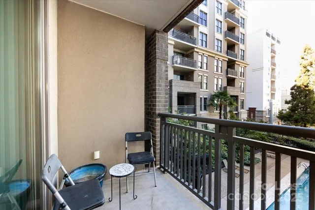 a view of a balcony with chairs and a potted plant