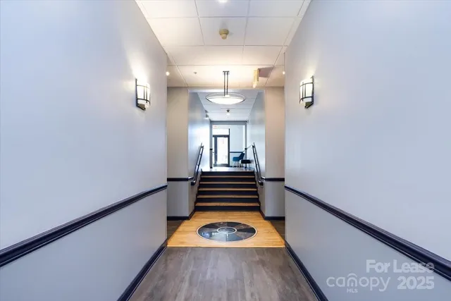 a view of a hallway with wooden floor and staircase
