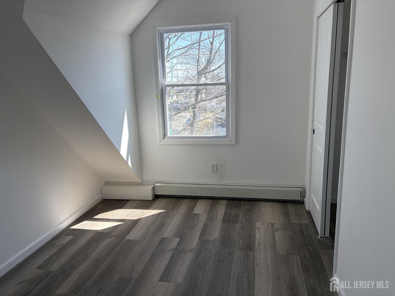 15 Fitch Street Carteret, NJ 07008 - Photo 3 of 8 an empty room with wooden floor and windows