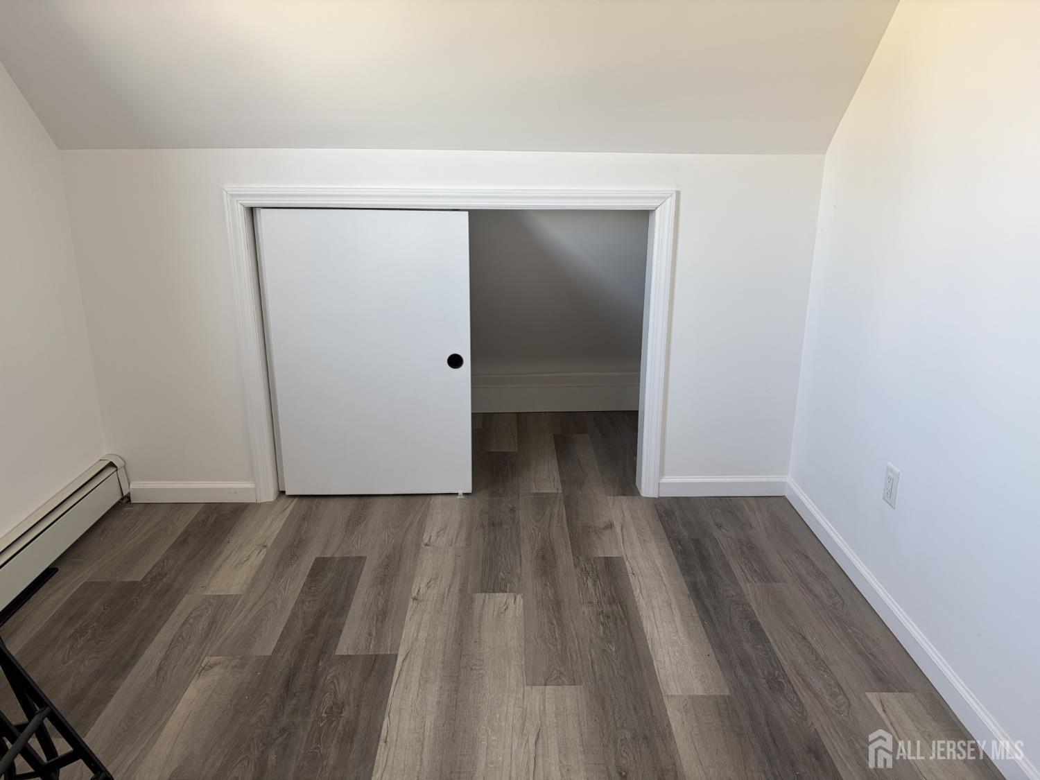 15 Fitch Street Carteret, NJ 07008 - Photo 4 of 8 a view of an empty room with wooden floor and closet