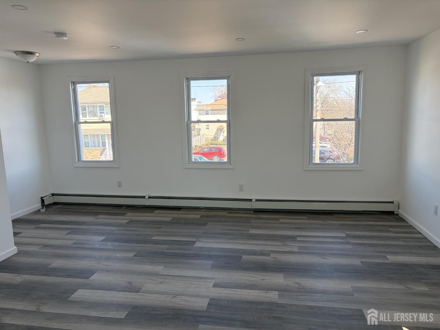 15 Fitch Street Carteret, NJ 07008 - Photo 5 of 8 a view of an empty room with wooden floor and window