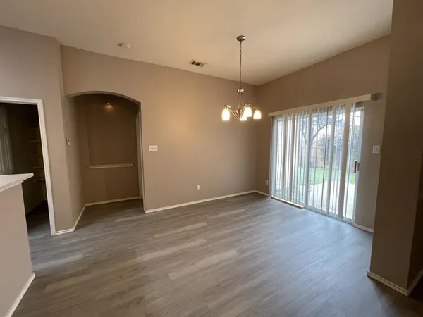 an empty room with wooden floor and window