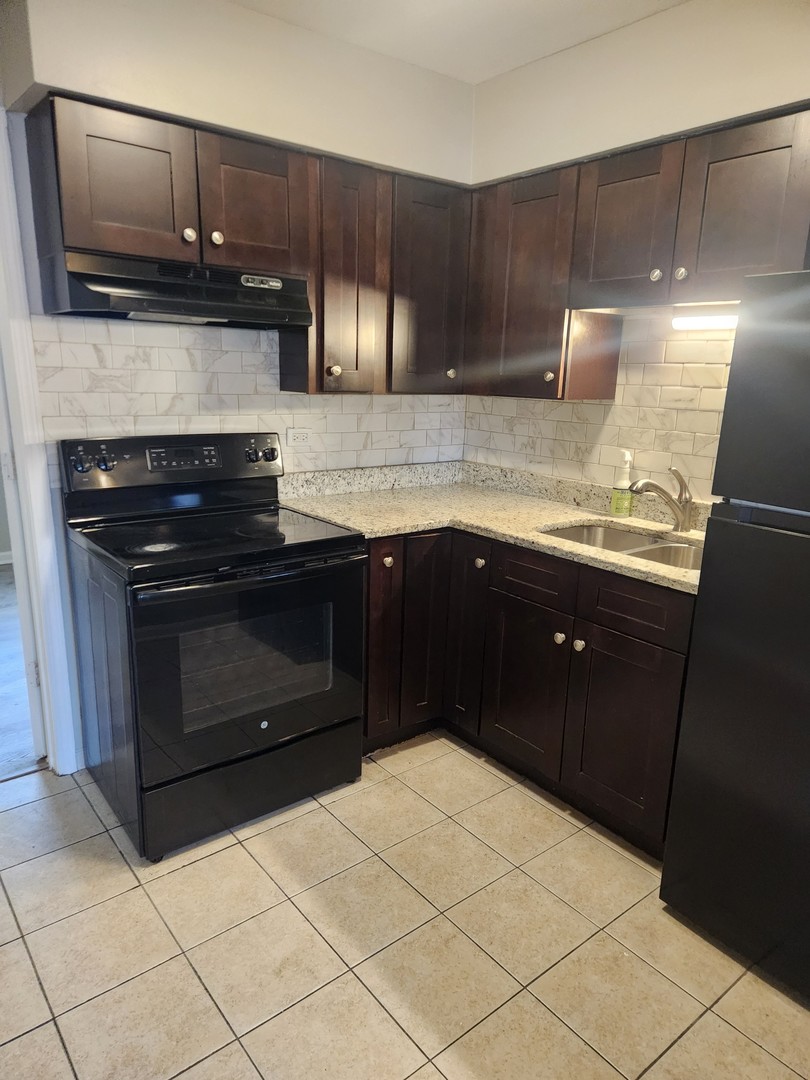 1340 North Main Street, Unit A8 Wheaton, IL 60187 - Photo 5 of 7 a kitchen with a sink and a stove top oven