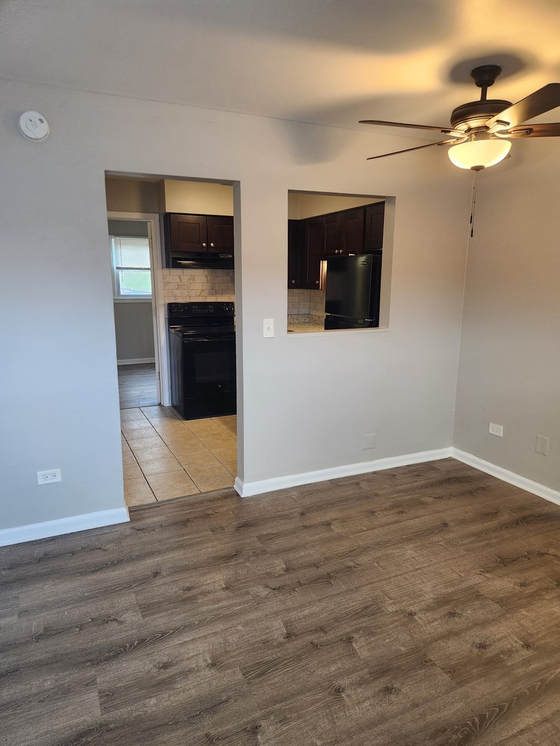 1340 North Main Street, Unit A8 Wheaton, IL 60187 - Photo 6 of 7 a view of an empty room with wooden floor and a window