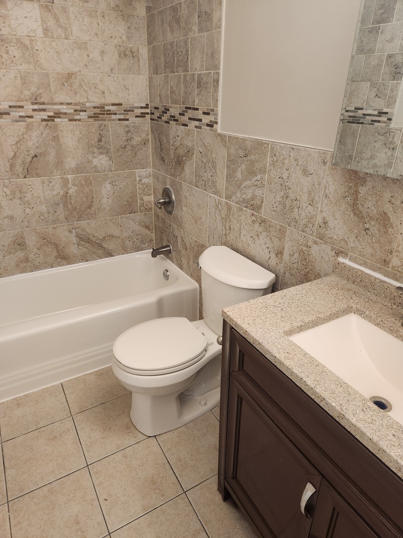 1340 North Main Street, Unit A8 Wheaton, IL 60187 - Photo 7 of 7 a bathroom with a sink a toilet and bathtub
