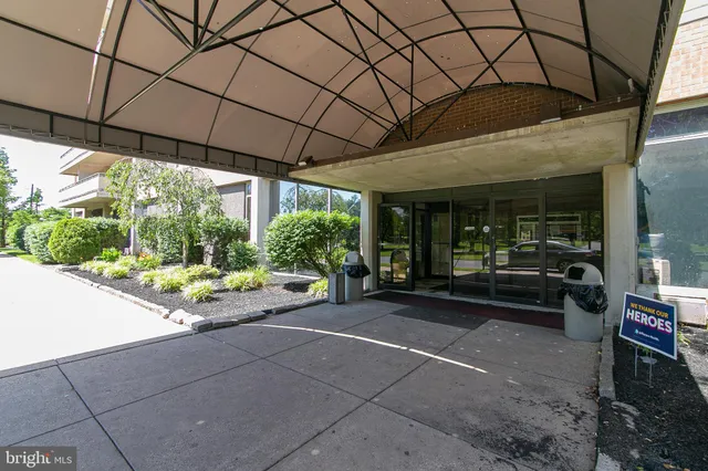 a view of a patio with table and chairs under an umbrella next to a yard