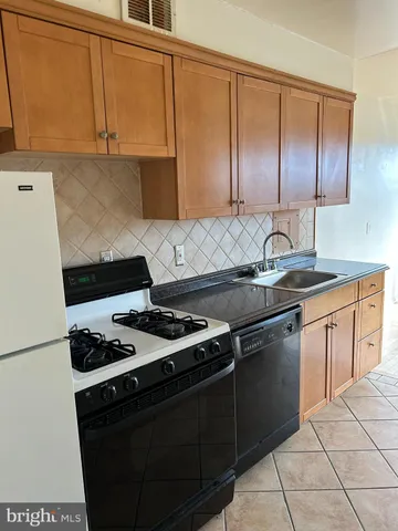 a kitchen with granite countertop a sink stove and cabinets