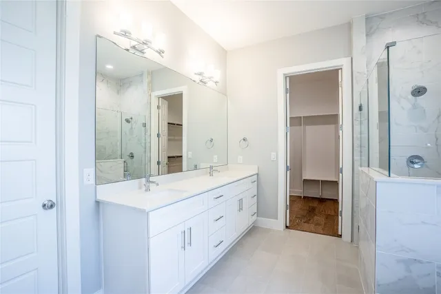 a spacious bathroom with a double vanity sink mirror and shower