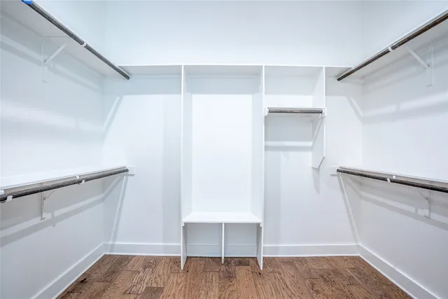a view of walk in closet with wooden floor