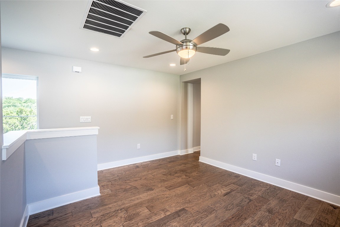 3018 Sunridge Drive, Unit 4 Austin, TX 78741 - Photo 28 of 34 an empty room with wooden floor fan and windows