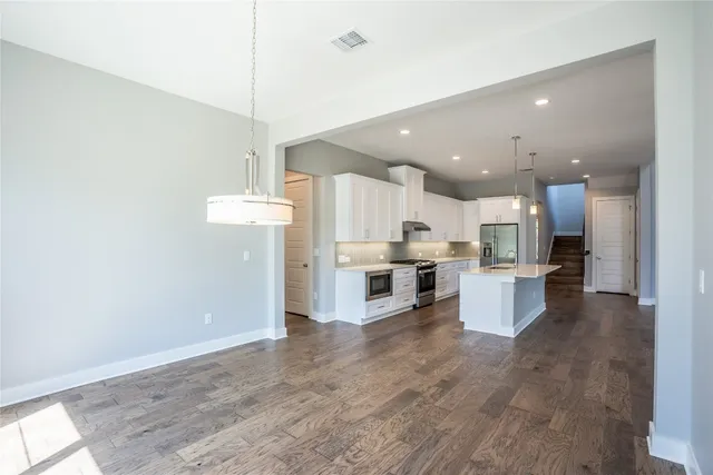 a large kitchen with a lot of counter space and stainless steel appliances