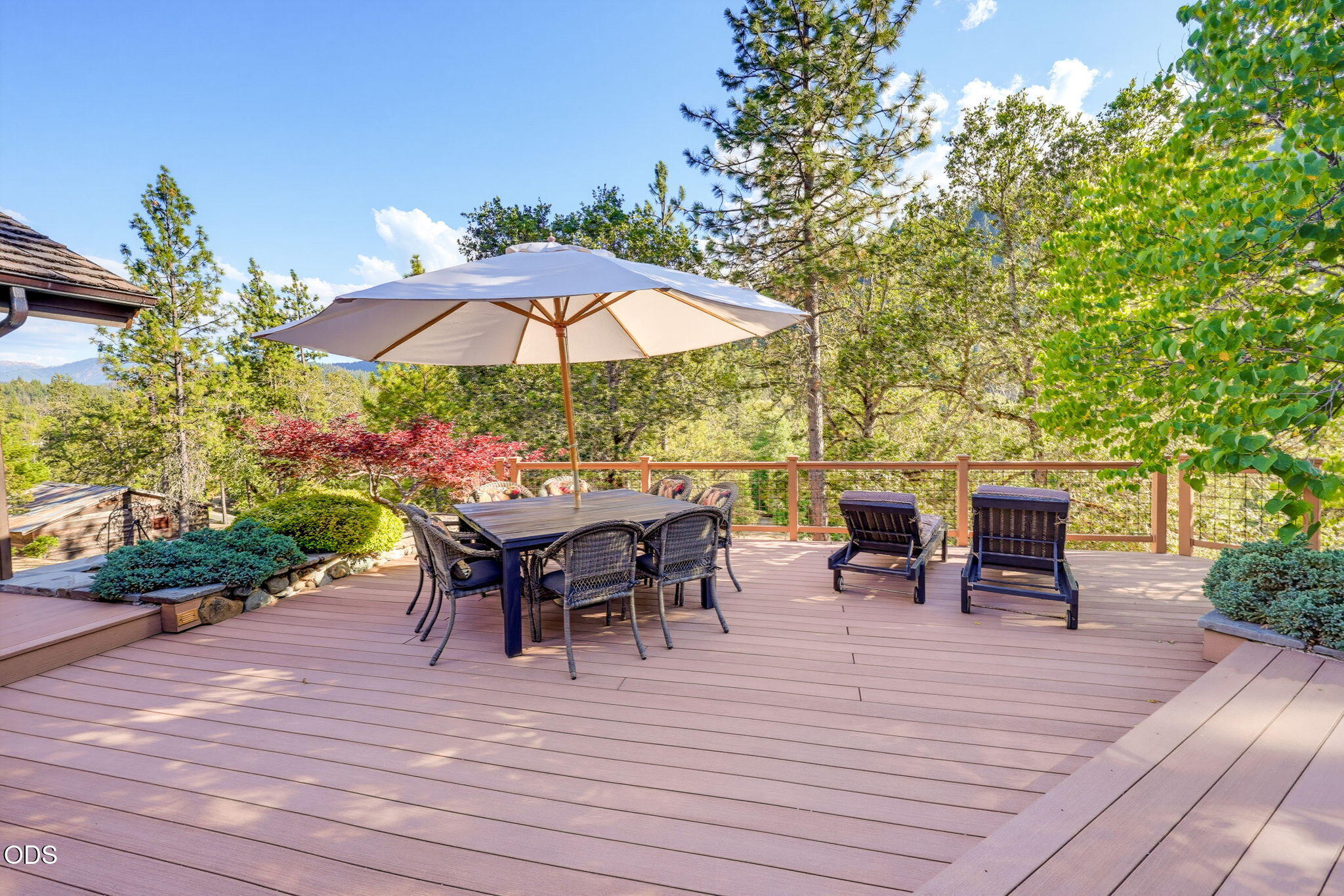 2459 Little Applegate Road Jacksonville, OR 97530 - Photo 5 of 86 a view of a roof deck with table and chairs under an umbrella with wooden floor