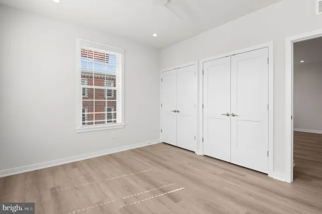 an empty room with windows and closet