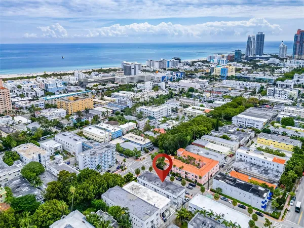 an aerial view of a city with lots of residential buildings ocean and mountain view in back
