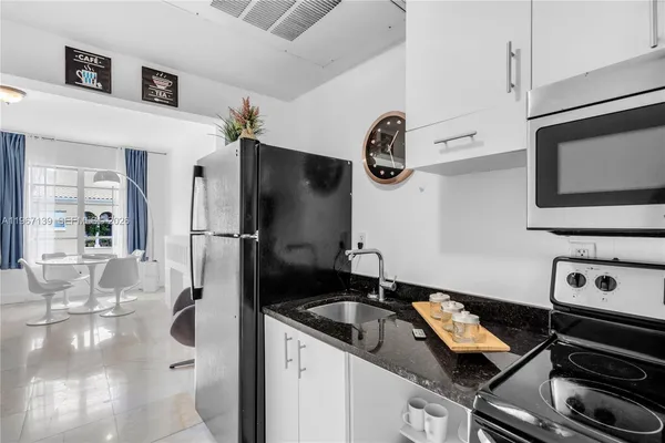 a kitchen with stainless steel appliances granite countertop a sink and a refrigerator