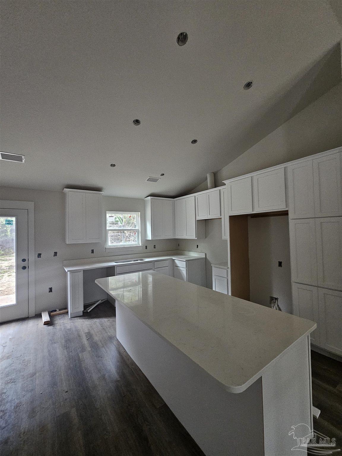 1056 Barth Road Molino, FL 32577 - Photo 2 of 4 a large kitchen with kitchen island a sink dishwasher stove and white cabinets