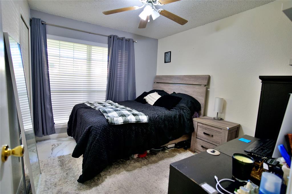 2025 High Bluff Drive Garland, TX 75041 - Photo 17 of 35 a bedroom with a bed and a chandelier