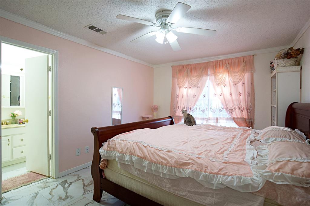 2025 High Bluff Drive Garland, TX 75041 - Photo 21 of 35 a bedroom with a bed and a chandelier