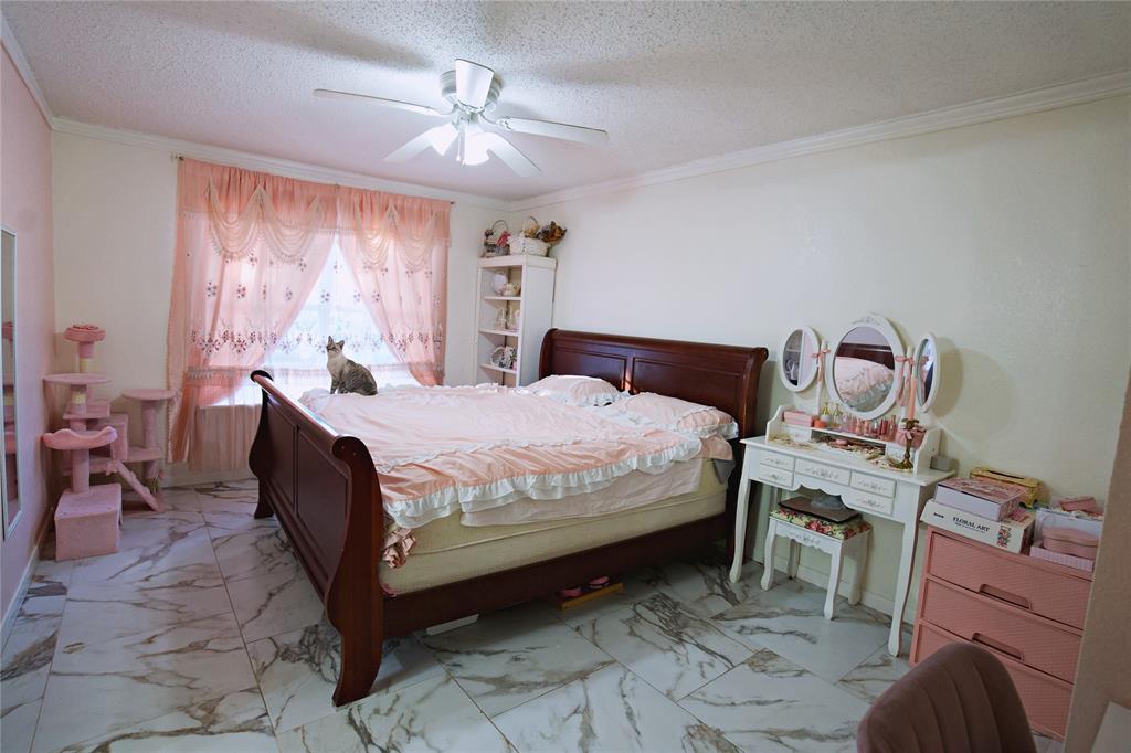 2025 High Bluff Drive Garland, TX 75041 - Photo 22 of 35 a bedroom with a bed and a chandelier