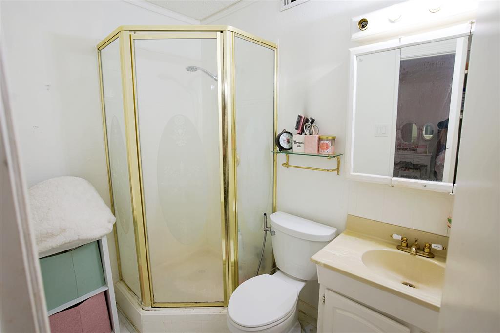 2025 High Bluff Drive Garland, TX 75041 - Photo 23 of 35 a bathroom with a toilet sink vanity and mirror
