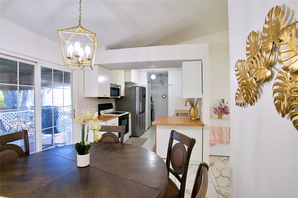 2025 High Bluff Drive Garland, TX 75041 - Photo 9 of 35 a view of kitchen and dining room with furniture wooden floor and a chandelier