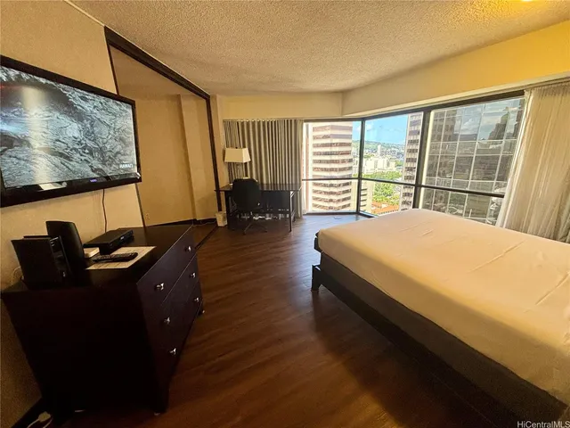 a bedroom with a bed window and a flat screen tv