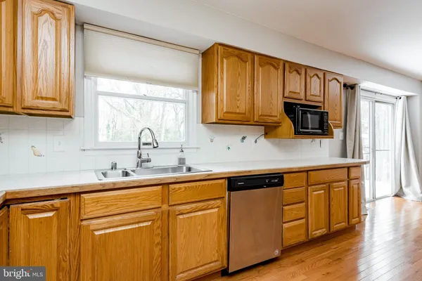 a kitchen with granite countertop wooden cabinets a sink and a window