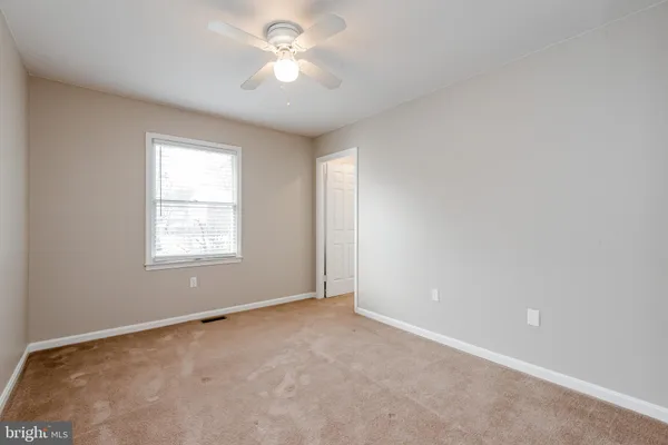 an empty room with a window and a ceiling fan