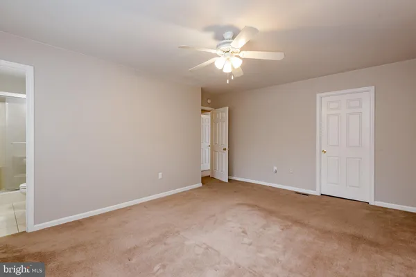 a view of an empty room with a chandelier fan