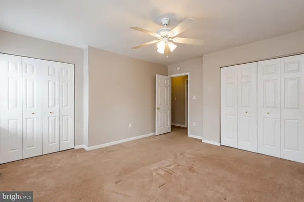 a view of an empty room and chandelier fan