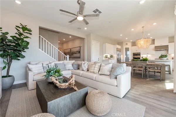 a living room with furniture kitchen and a potted plant