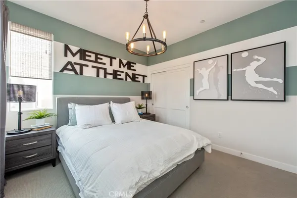a bedroom with a bed mirror and a window