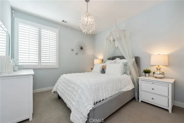 a bedroom with a bed and a chandelier