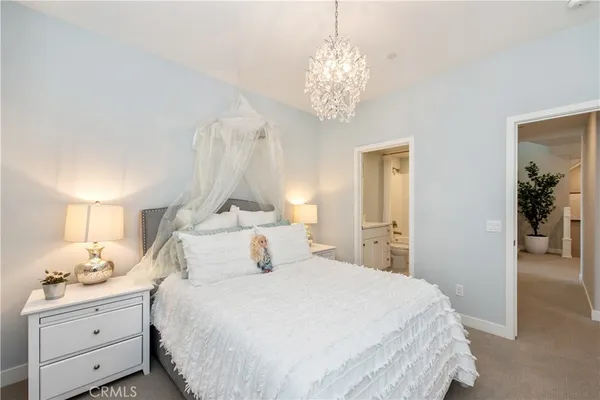 a bedroom with a large bed and a chandelier