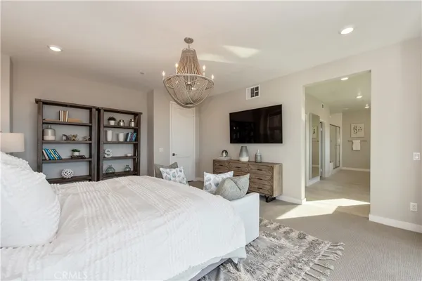 a bedroom with a bed and a flat tv screen on dresser