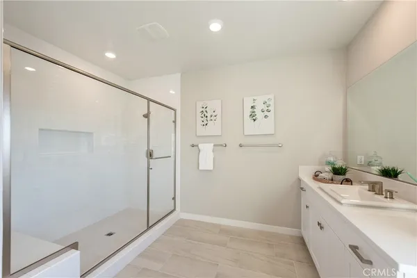 a large white kitchen with a white countertops a sink and a large window