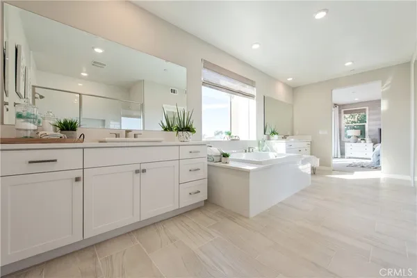 a view with counter top space sink and a mirror
