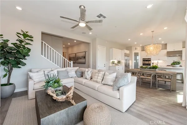 a living room with furniture kitchen and a chandelier