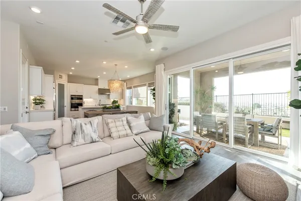 a living room with furniture kitchen and a large window