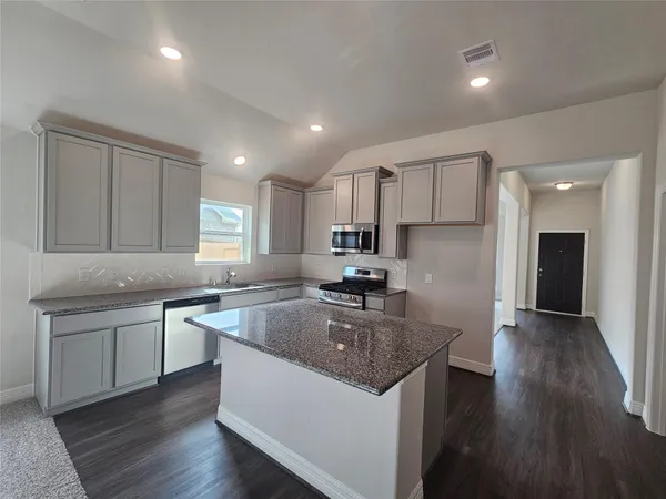 a kitchen with stainless steel appliances granite countertop a sink stove and refrigerator