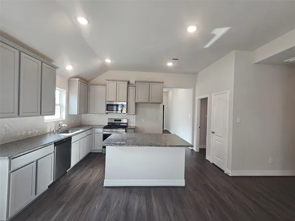 a large kitchen with stainless steel appliances lots of counter top space and cabinets