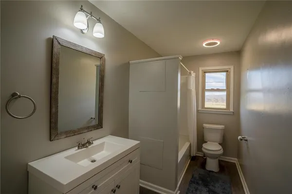 a bathroom with a sink toilet and a mirror
