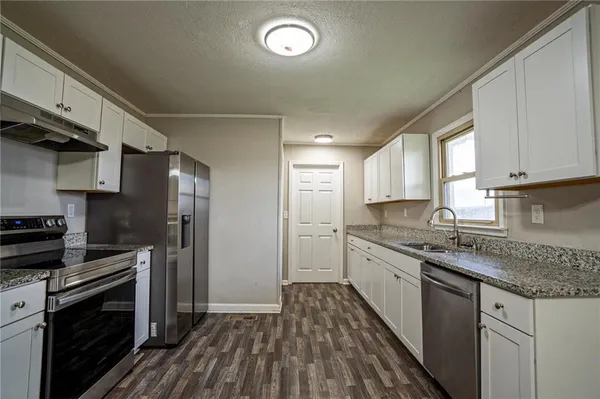 a kitchen with stainless steel appliances granite countertop a stove a sink and a refrigerator