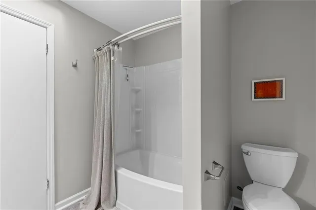 a bathroom with a toilet and shower