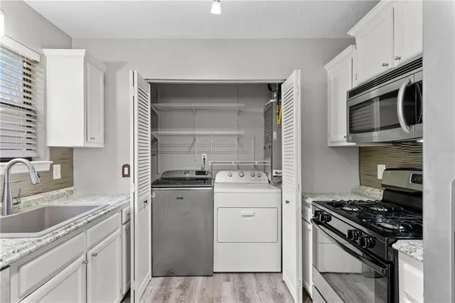 a kitchen with stainless steel appliances a sink stove and cabinets