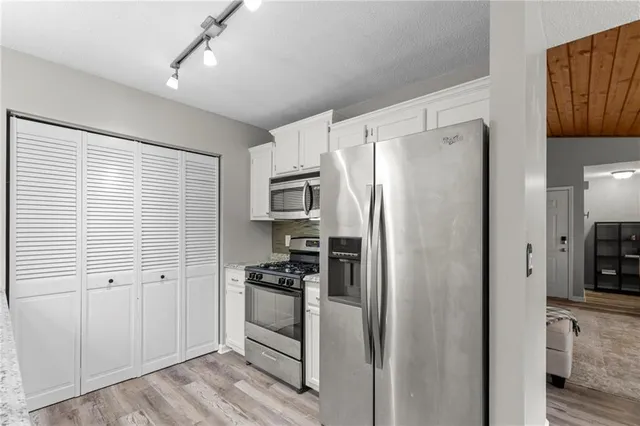 a kitchen with stainless steel appliances a refrigerator and a stove top oven
