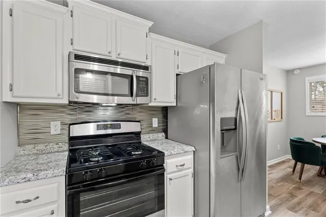 a kitchen with stainless steel appliances and white cabinets