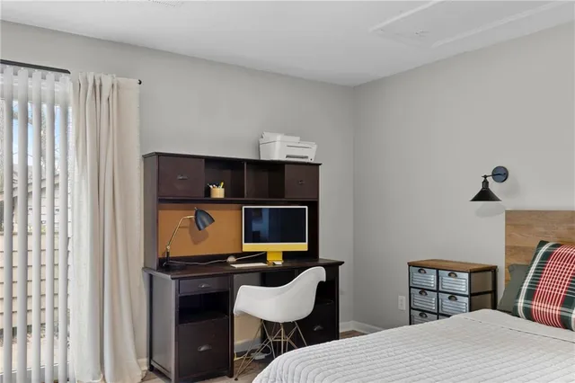 a bedroom with a bed a chair and plant