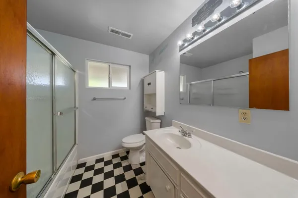 a bathroom with a sink a toilet and shower